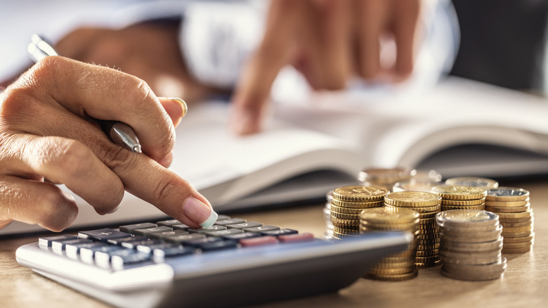 Man and woman hand consider on calculator expenses of family budget