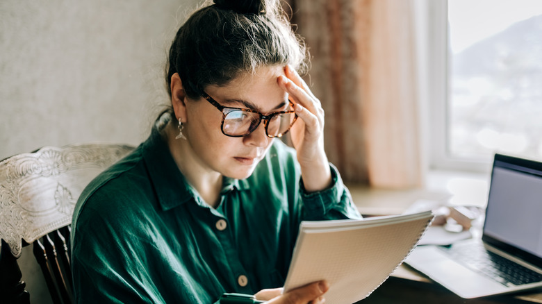 A woman looking stressed reading notes