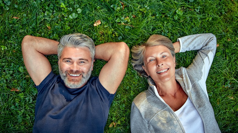 Retired couple laying on grass