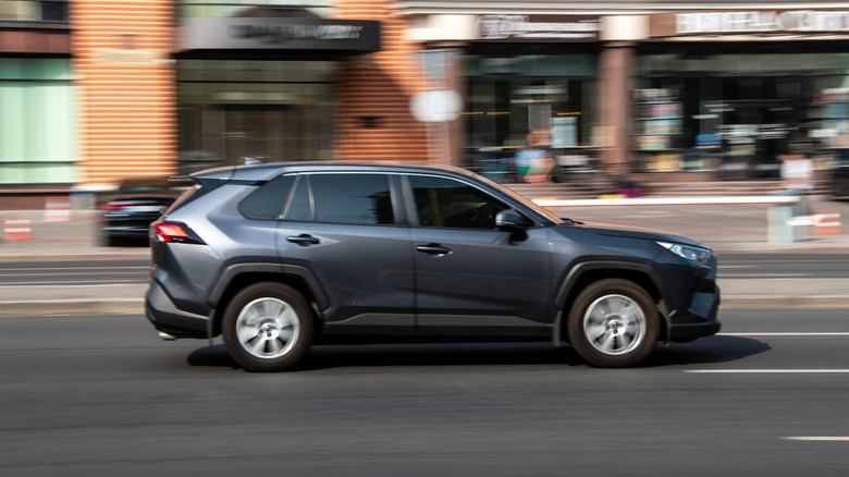 Blue Toyota RAV4 driving on a city street