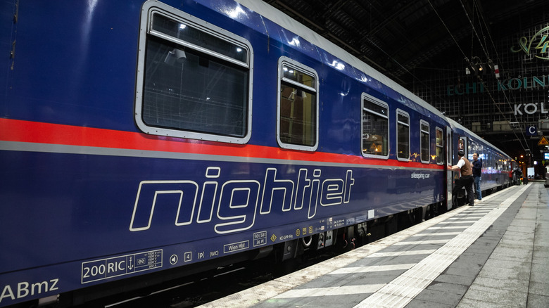 people getting on a train in the evening