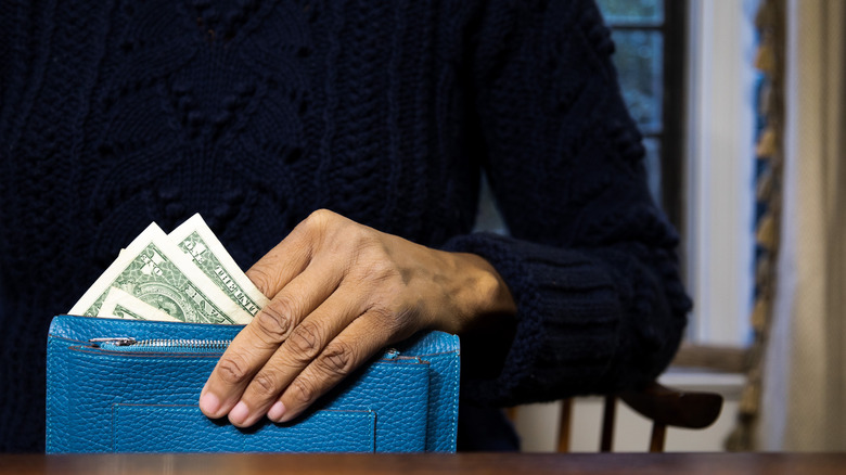 Person holding wallet with cash