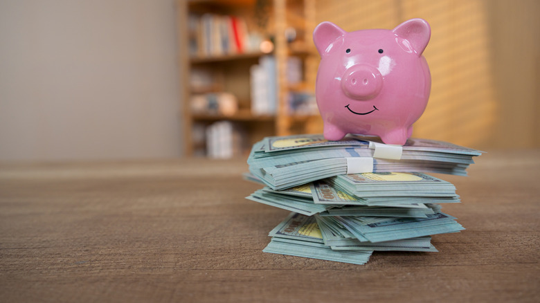 piggy bank on stacks of $100 bills