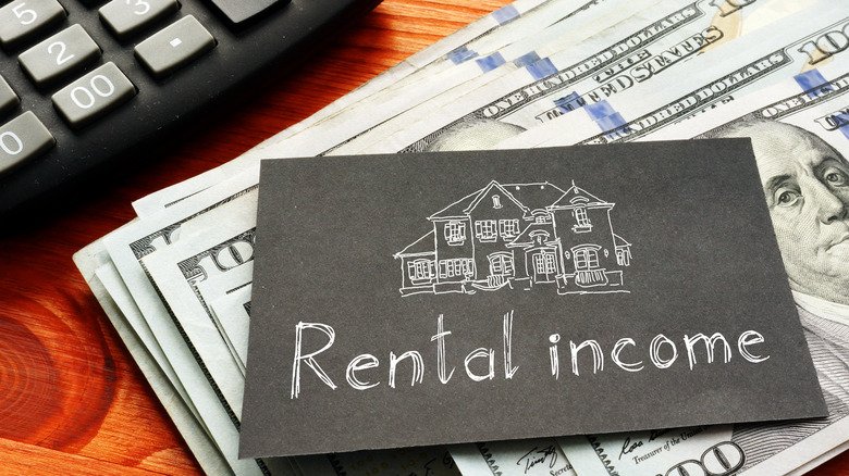 rental income on paper above $100 bills and calculator