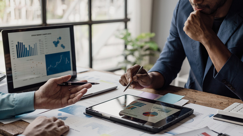 A man looking at an investment portfolio with his advisor.