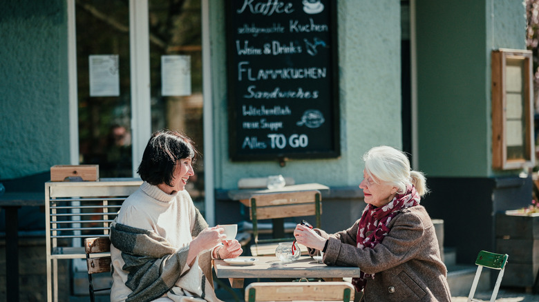 Two women enjoying coffee at an outdoor bistro