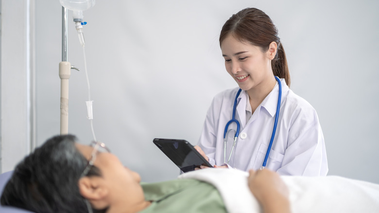 Female doctor discuss and follow up patient on bed at hospital