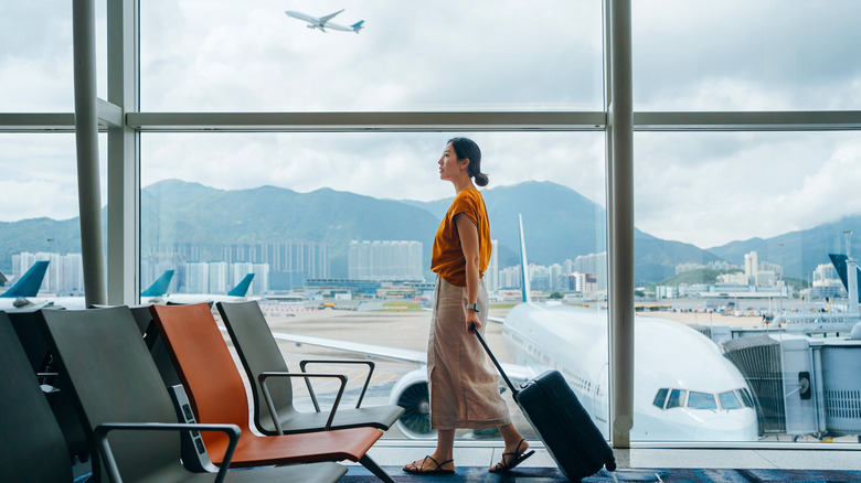 Woman walking through airport with luggage