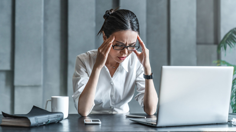 Women stressed and looking at computer.