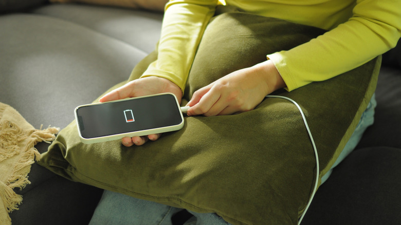 Person connecting phone to charger.