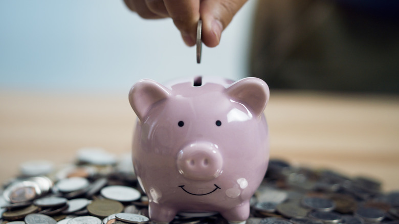 putting a coin in a piggy bank