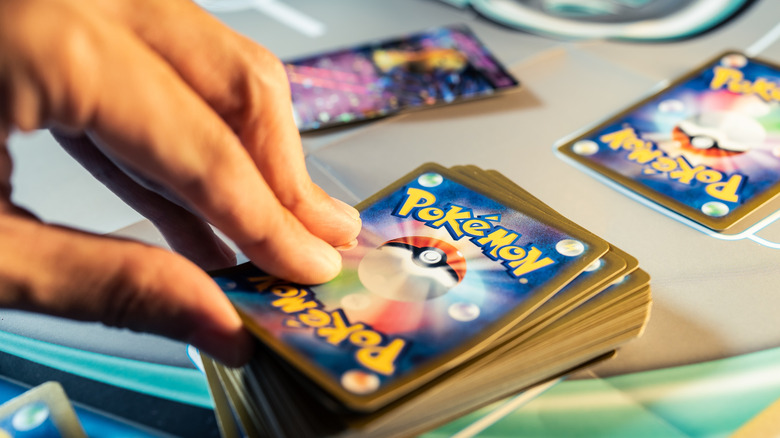 Fingers on a deck of Pokemon cards