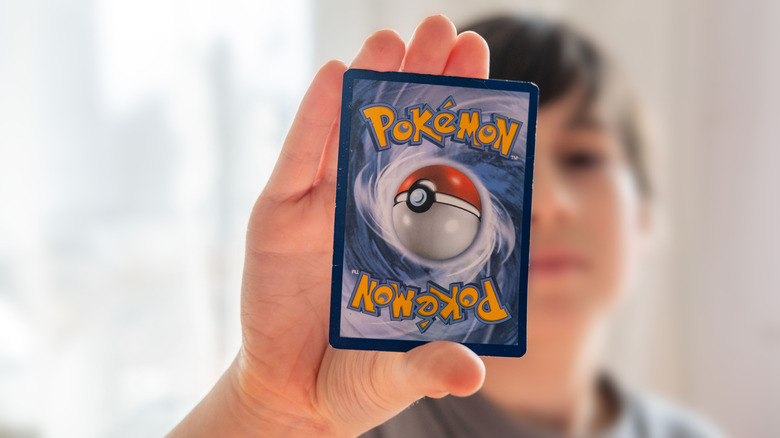 Kid holding up a Pokemon card