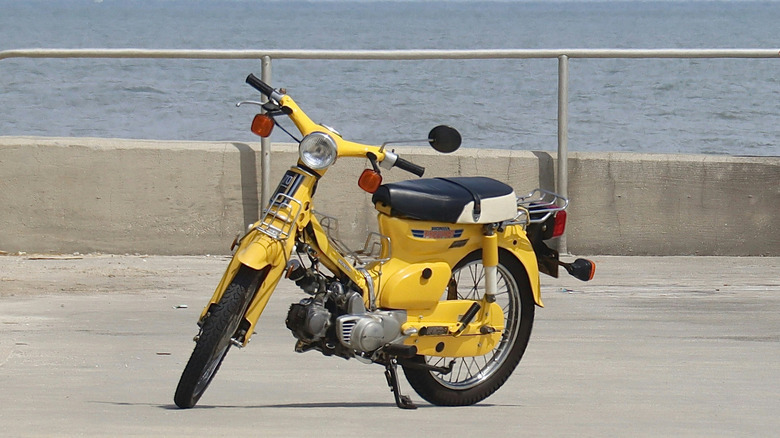 yellow motorcycle parked next to the ocean