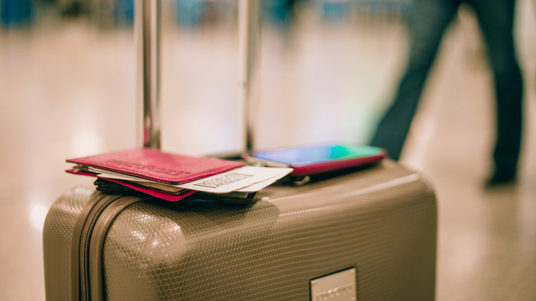 Close-up of luggage with passport and smart phone in the airport