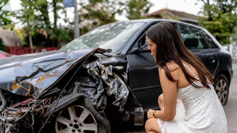 Woman looking at her wrecked car