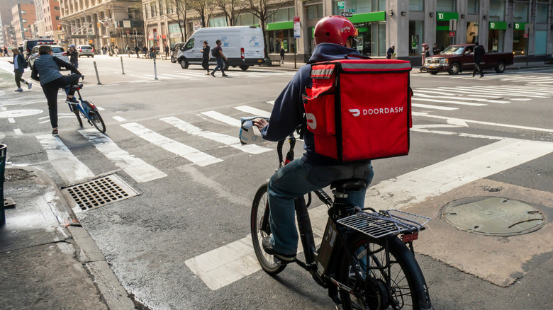 Man on bicycle in the city with DoorDash delivery
