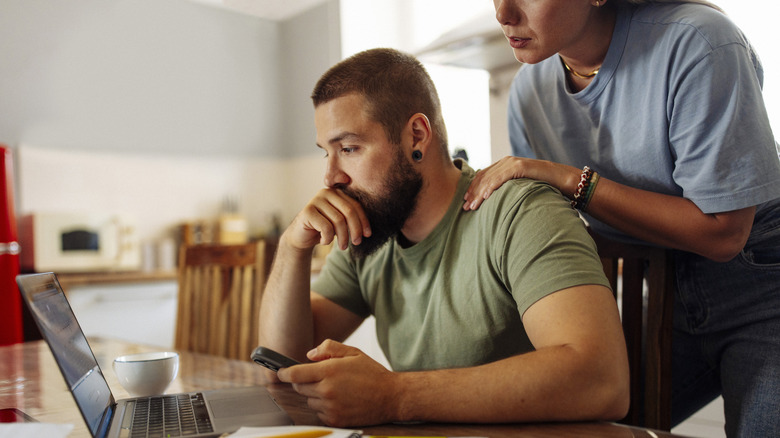Couple worried and looking at computer.