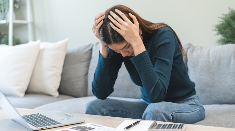 woman upset looking at bills
