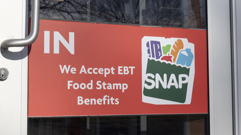 A red sign with a SNAP logo on a grocery store doorway