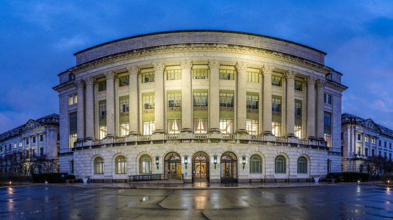 The Department of Agriculture building, lit up on a rainy night street