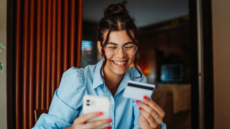 woman checking card balance on phone