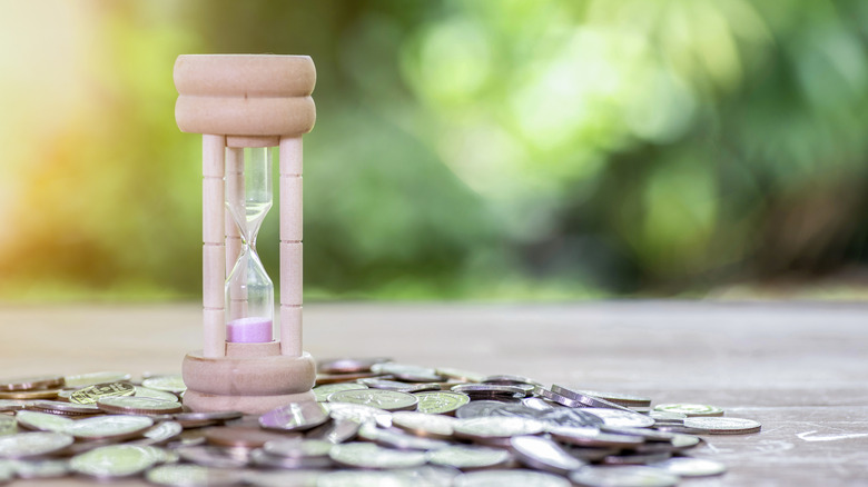 stack of coins and an hourglass