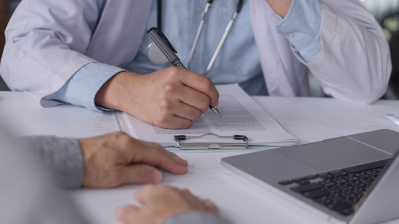 hands of an older patient and doctor