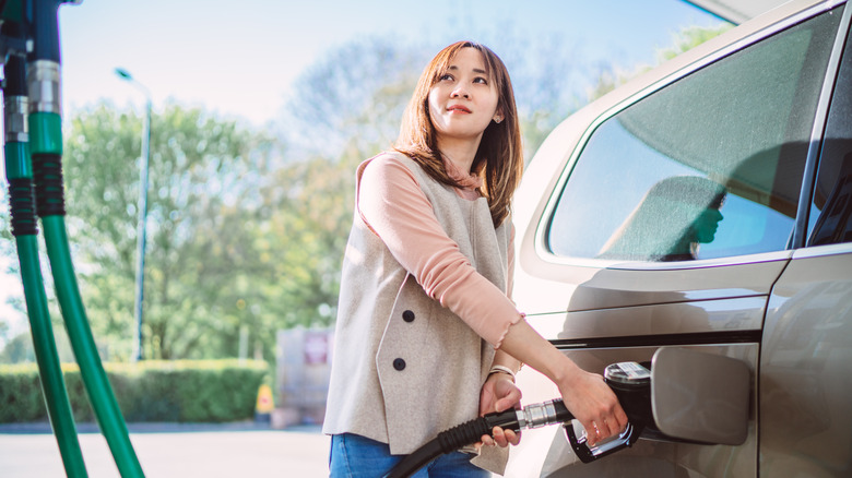 Woman pumping gas into car
