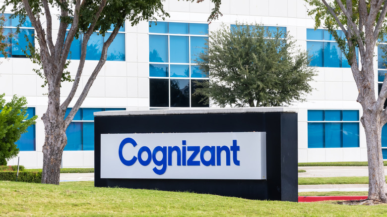 The exterior of a white Cognizant Technology Solutions building with a sign and trees out front