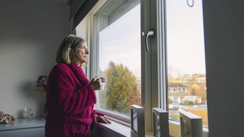 Older woman looking out a window