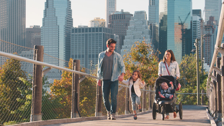 Family walking across bridge with Manhattan skyline in background
