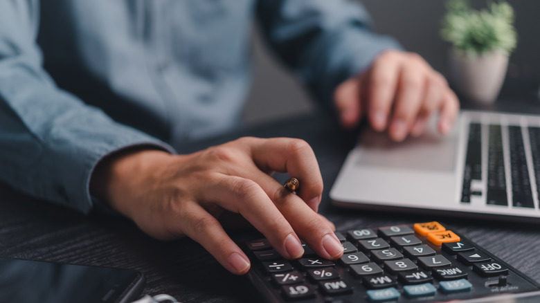 Person using calculator at desk