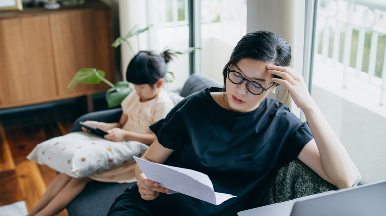 A Millennial mother looking stressed while managing her taxes.