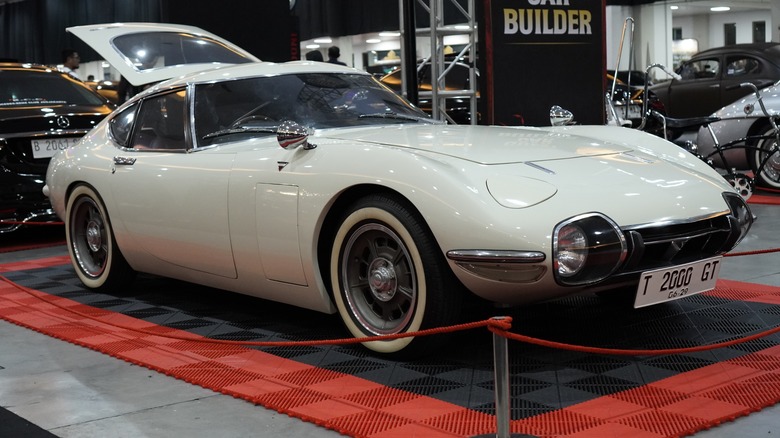 a white 1970 Toyota 2000GT in a showroom