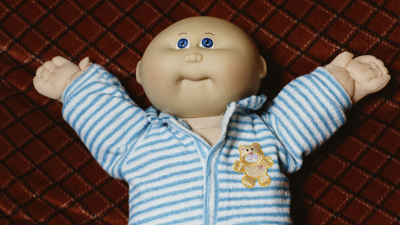 bald little people doll with blue striped shirt