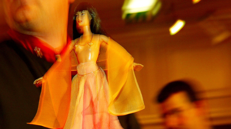 DeBeers Barbie held in a man's hand
