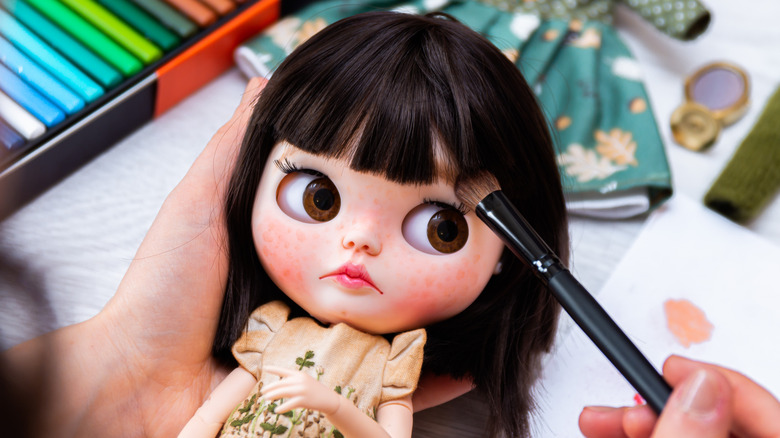 wide-eyed  doll with blue eyes and pink lips