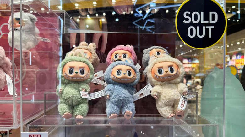 Labubu plush toys sit in a window display