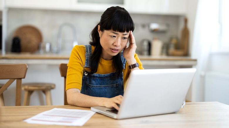 A frustrated young woman dealing with a problem on her computer