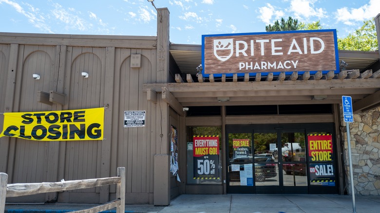 Front of Rite Aid pharmacy with yellow "store closing" sign
