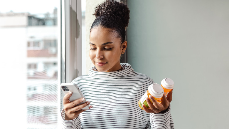 woman holding prescription bottles
