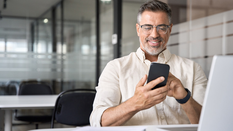 man with phone and laptop