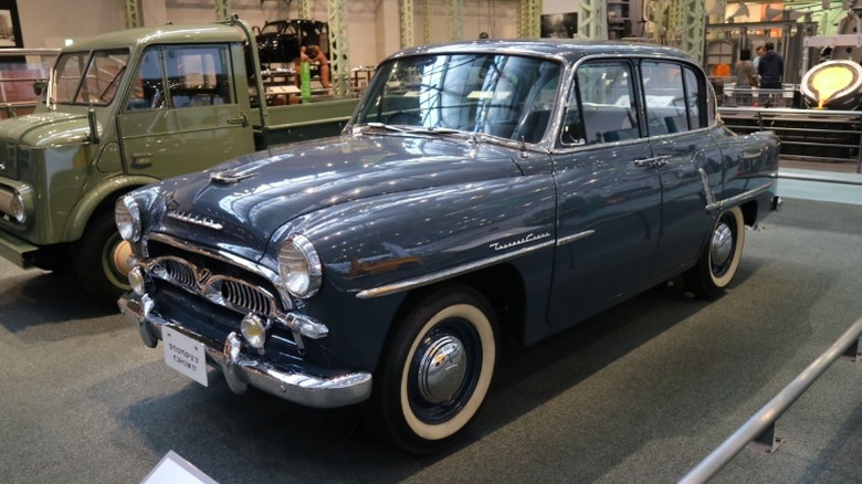 A well-preserved vintage 1950s Toyopet Crown vehicle on display in a museum.