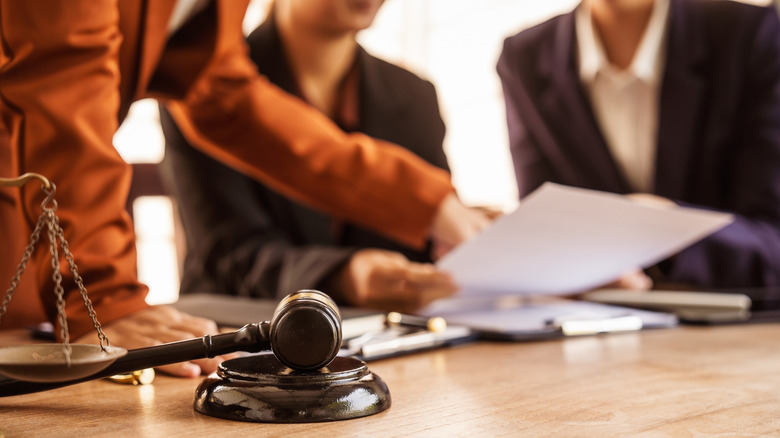 lawyers examine a document in a courtroom