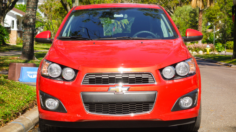 A red Chevrolet Sonic parked on a street.