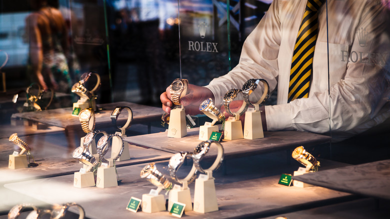 A Rolex employee organizing a store window