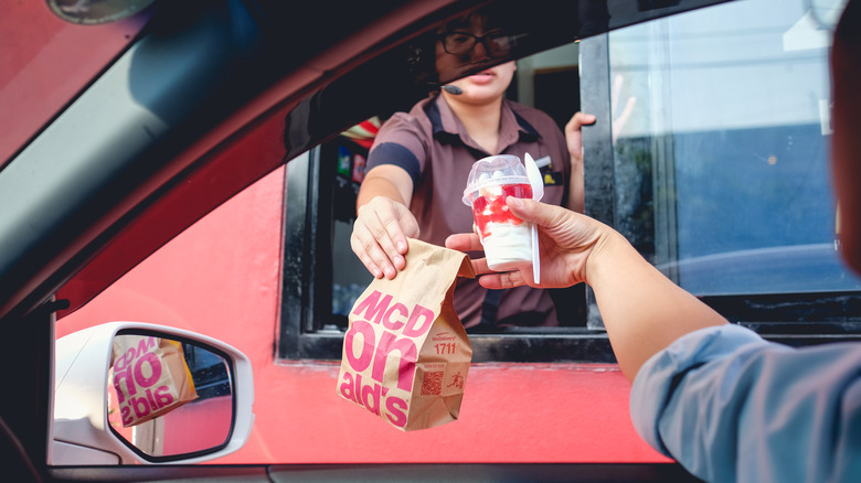 driver picking up a bag of McDonald's