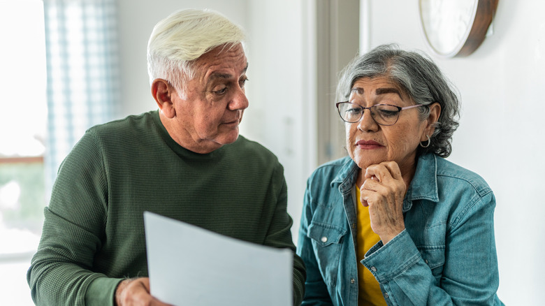 An older couple looking confused as they look over their tax documents