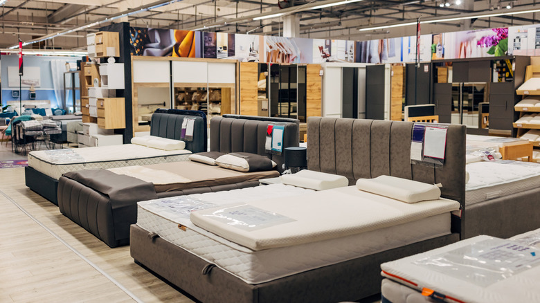 Multiple beds and mattresses on display in a medium lit mattress store